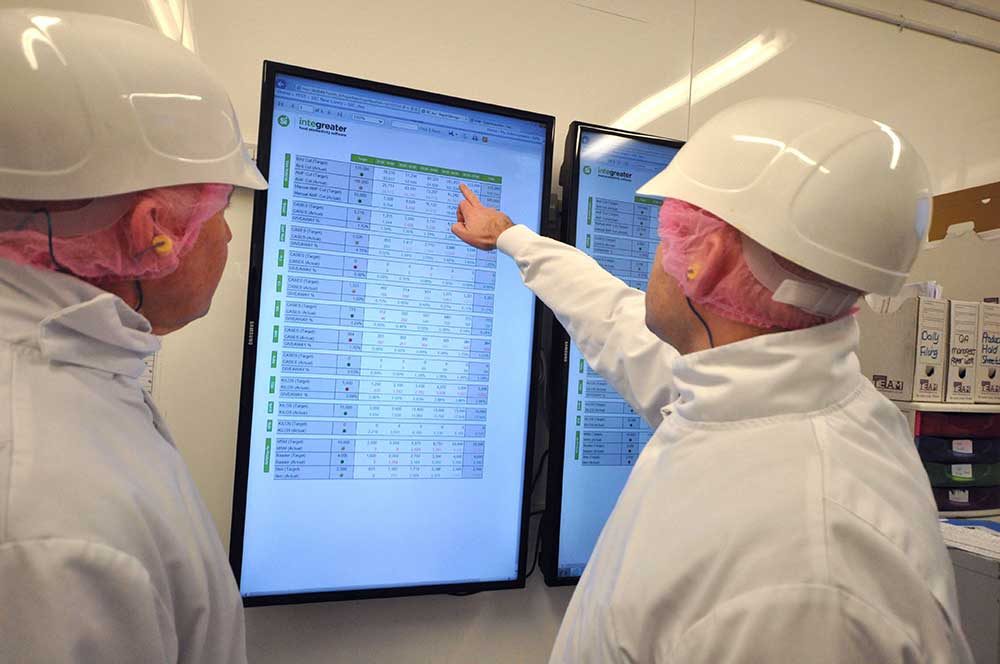 Image of two workers reviewing real-time data on dashboard.
